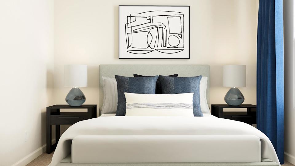 A bed with a white bed spread.