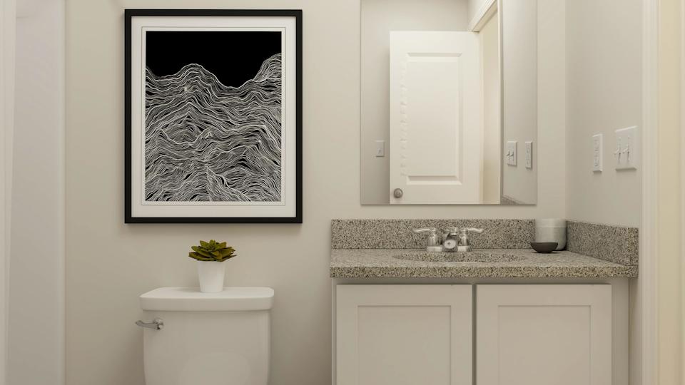 A bathroom with a picture on the wall.