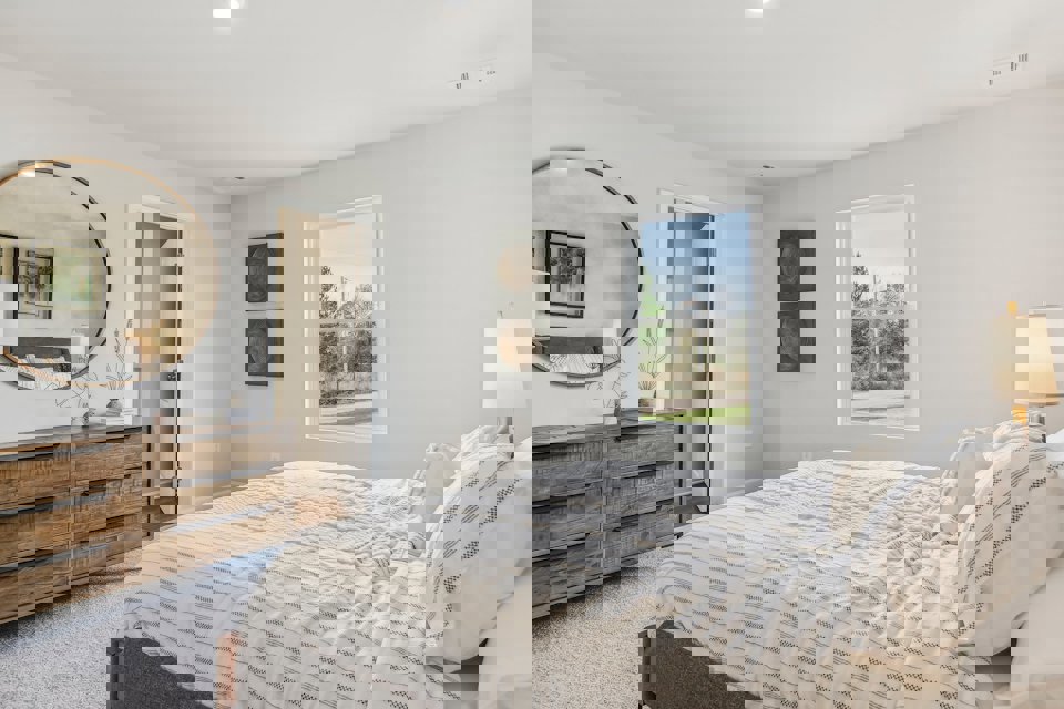 A bedroom with a large mirror.