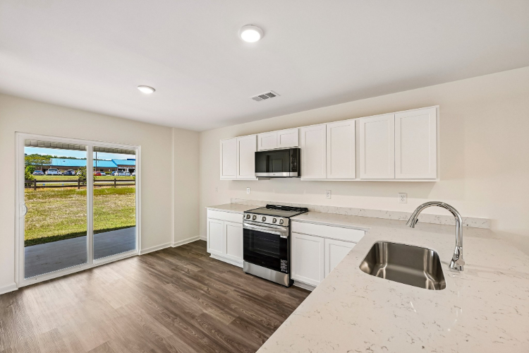 A kitchen with white cabinets.