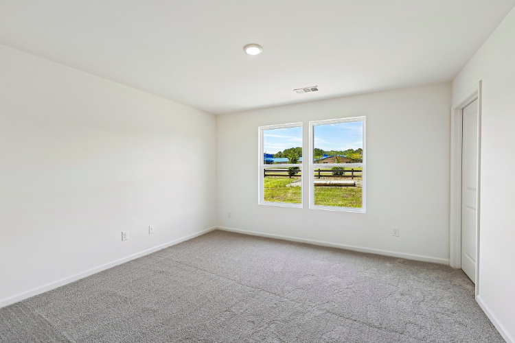 A room with a window and a carpet.