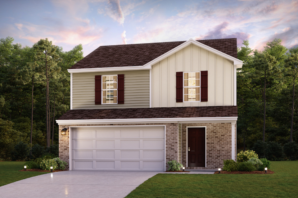 A house with a garage and trees in the back.