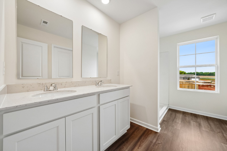 A bathroom with white cabinets.