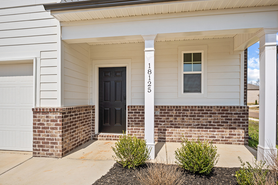 A house with a brick wall and a brick driveway.
