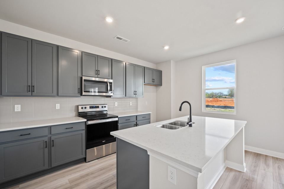A kitchen with black cabinets.