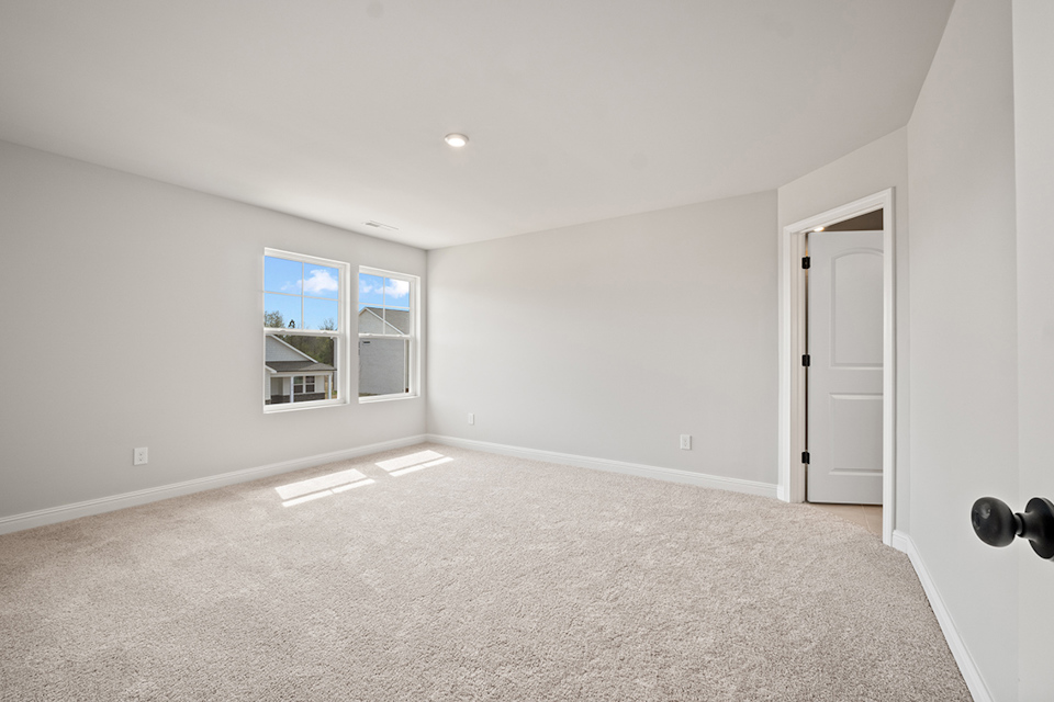 A room with a carpet and a window.
