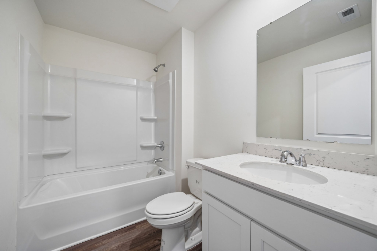 A bathroom with a tub sink and toilet.