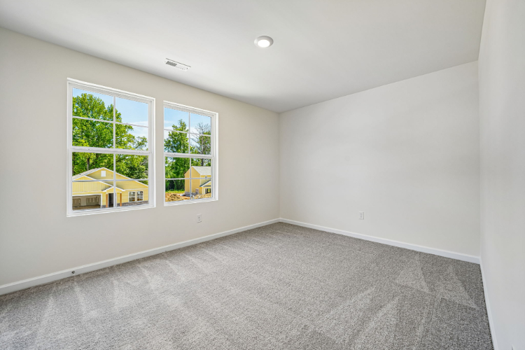 A room with a window and a rug.
