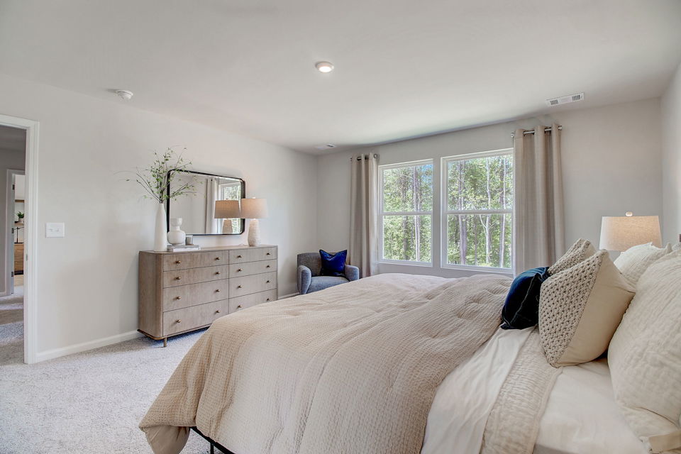 A large bedroom with a bed and a dresser.