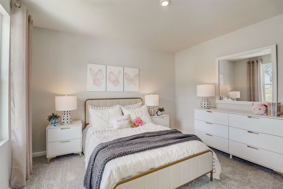 A bedroom with a bed and lamps.