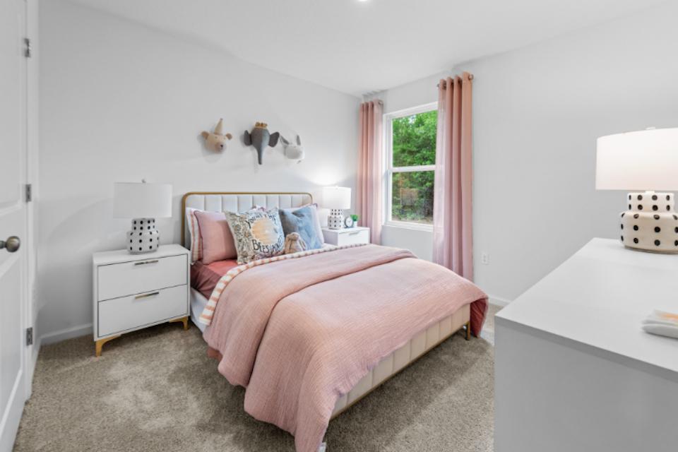 A bedroom with a pink bed.