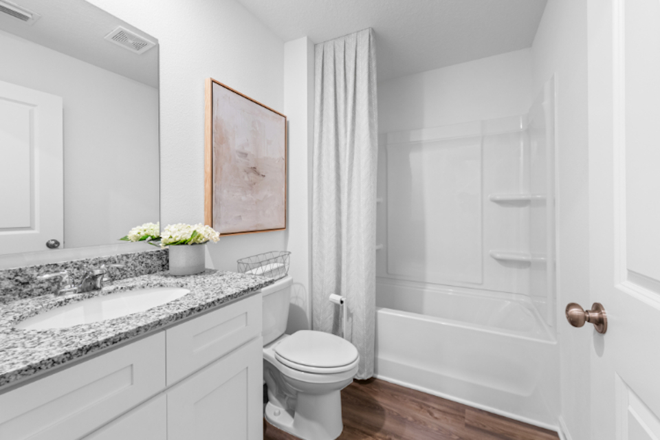 A bathroom with a tub sink and toilet.
