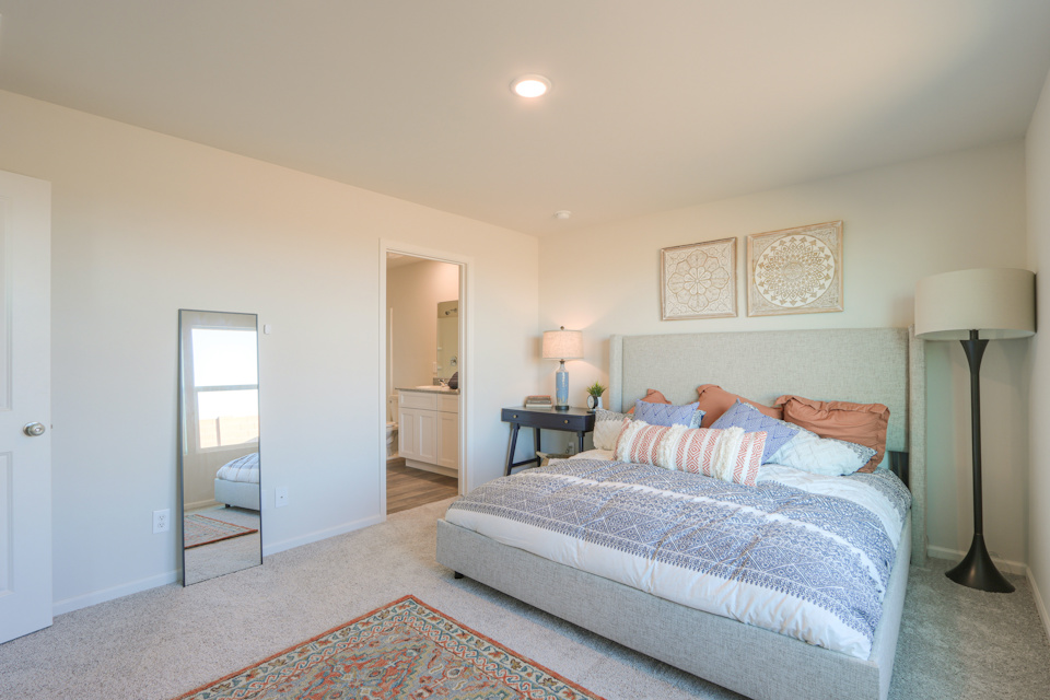 A bedroom with a bed and lamps.