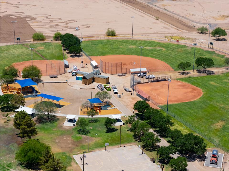 A large field with a few buildings.