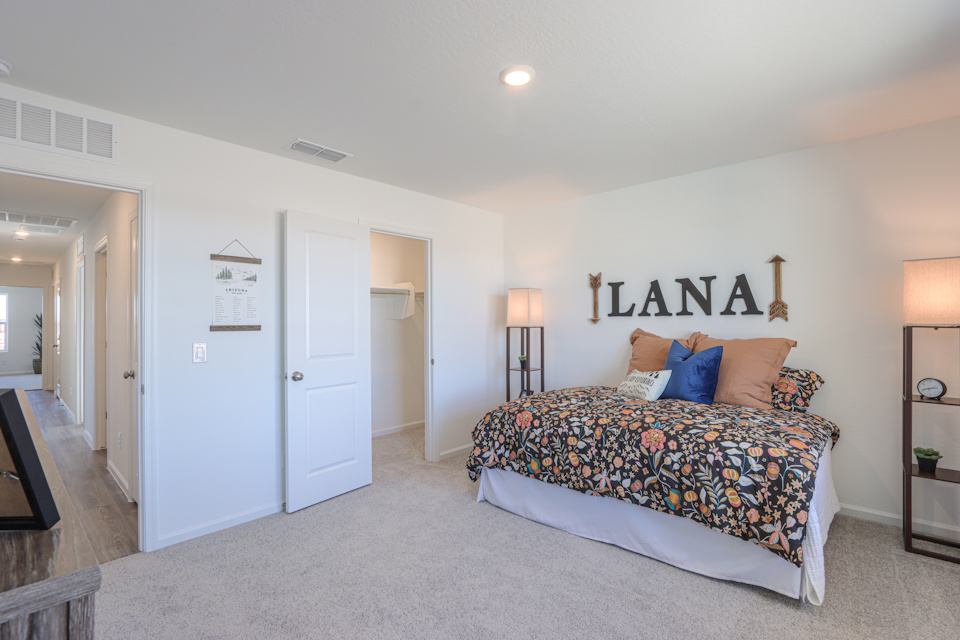 A bedroom with a bed and a lamp.