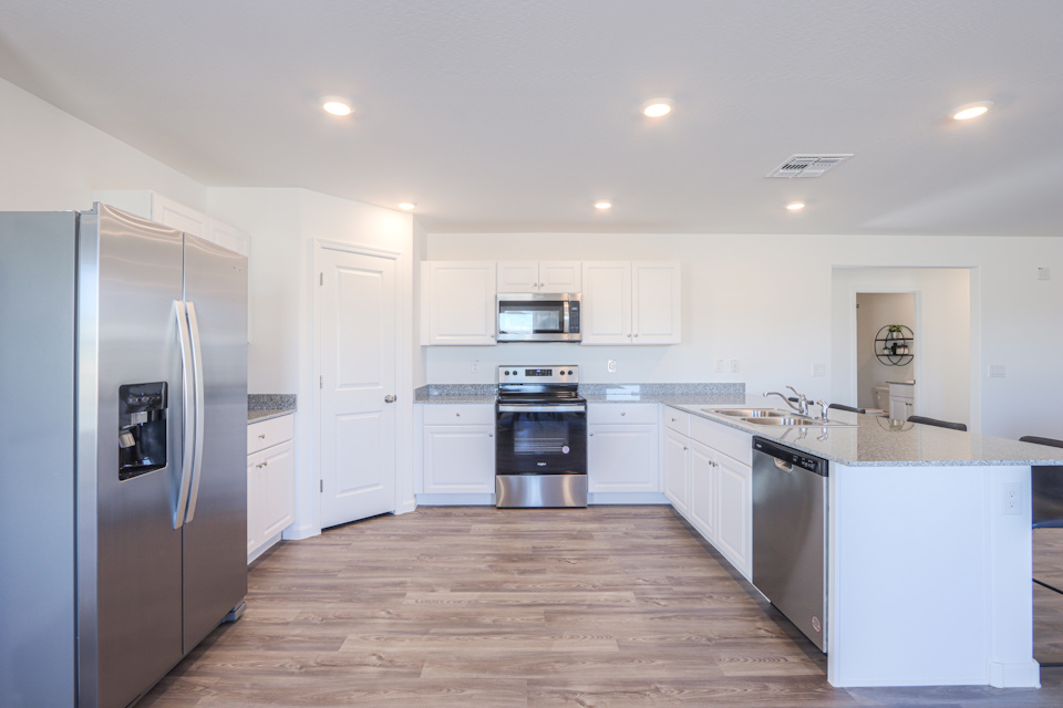A kitchen with white cabinets.