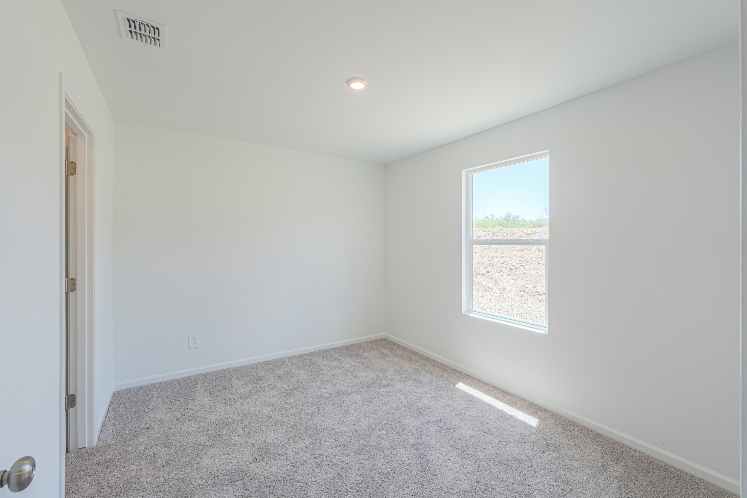 A room with a carpet and a window.