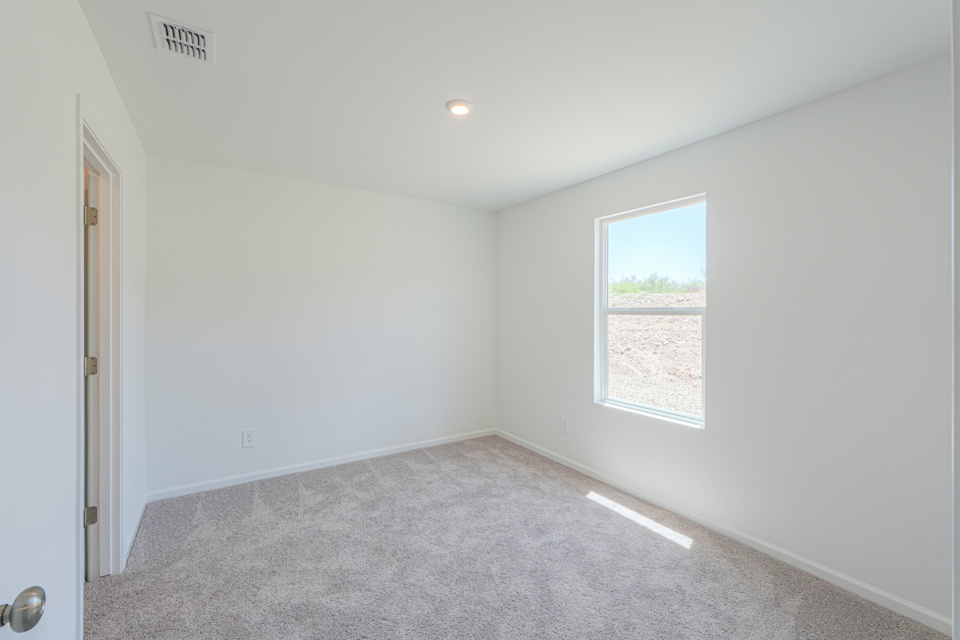 A room with a carpet and a window.