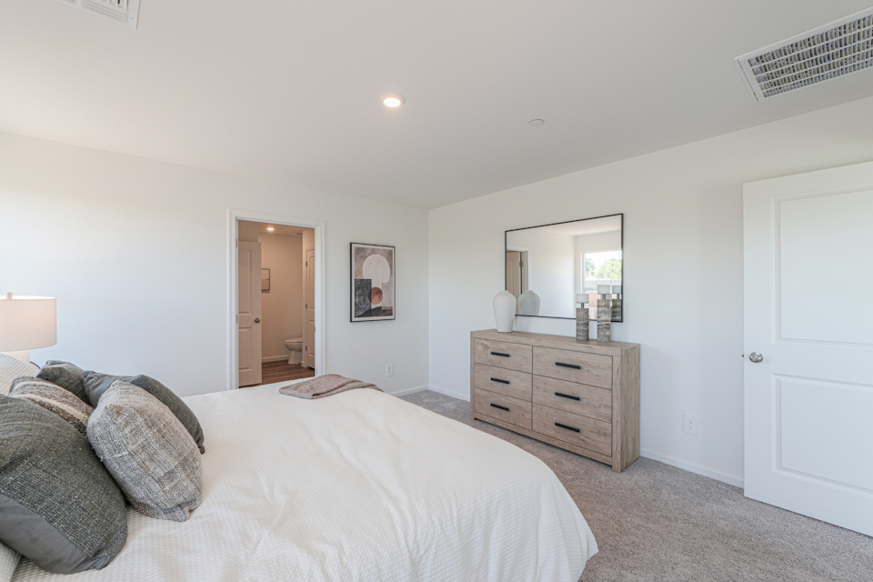 A bedroom with a bed and dresser.