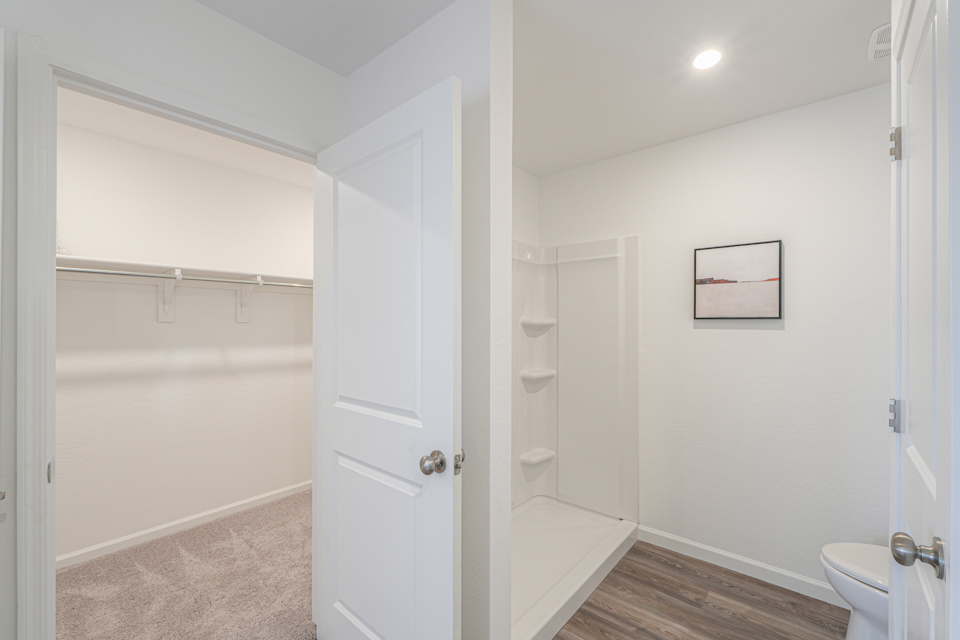 A bathroom with a shower unit and toilet.