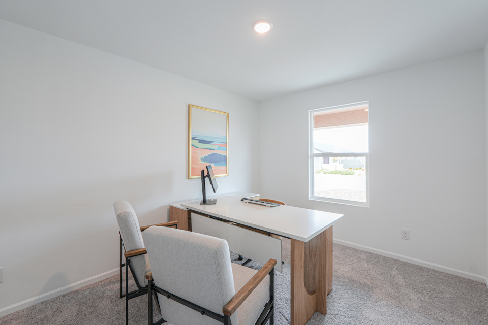 A room with a desk and chairs.