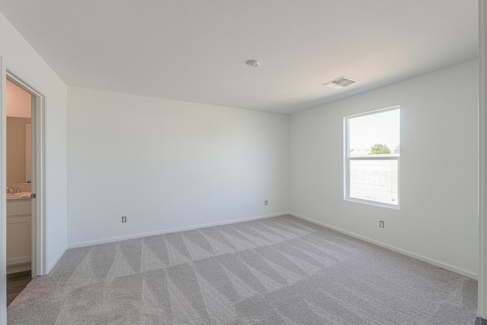 A room with a carpet and a window.