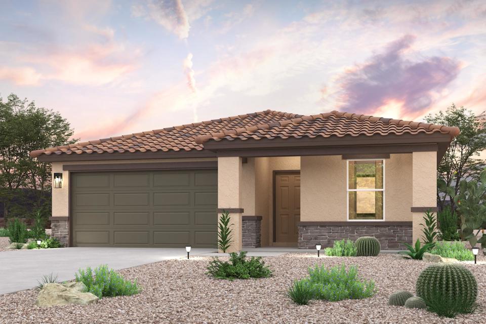 A house with a garage and bushes in front of it.