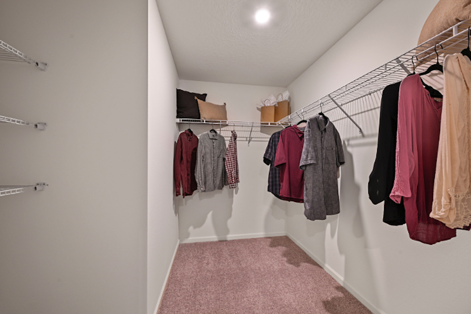 A room with a rack of clothes.