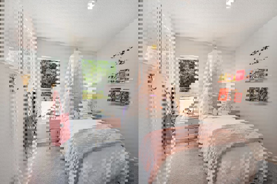 A bedroom with a bed and a window.