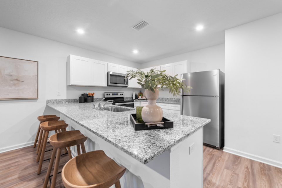 A kitchen with a table and stools.