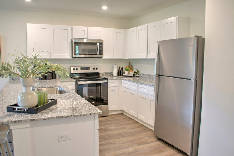 A kitchen with white cabinets.