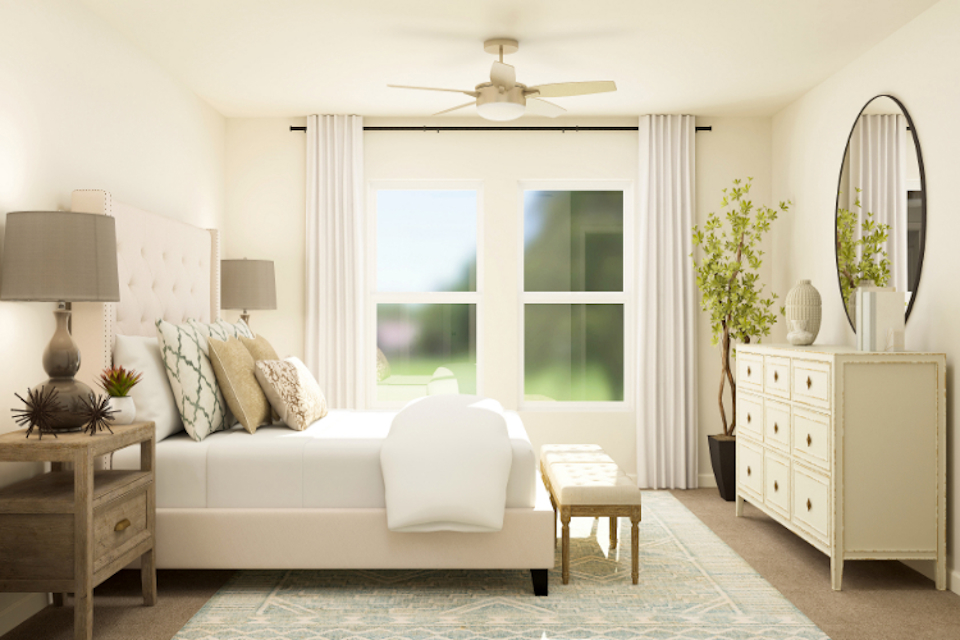 A living room with a white couch and a fan.