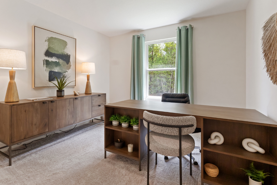 A room with a desk and chairs.
