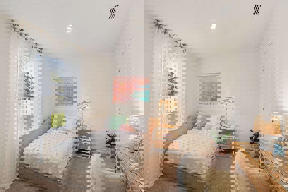 A bedroom with a bed and a window.