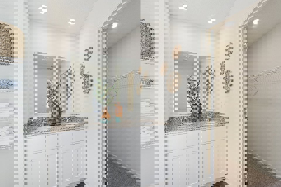 A bathroom with white cabinets.