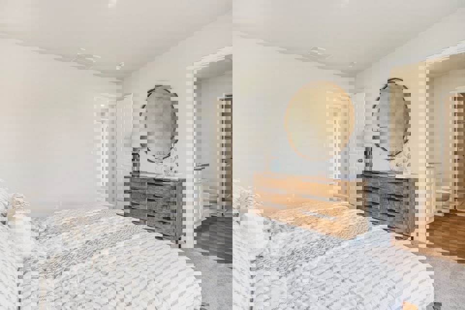 A bedroom with a large mirror.