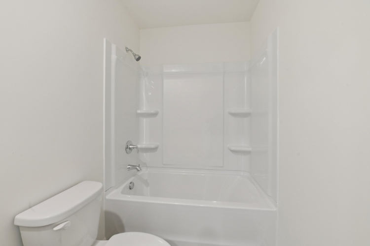 A bathroom with a tub and toilet.