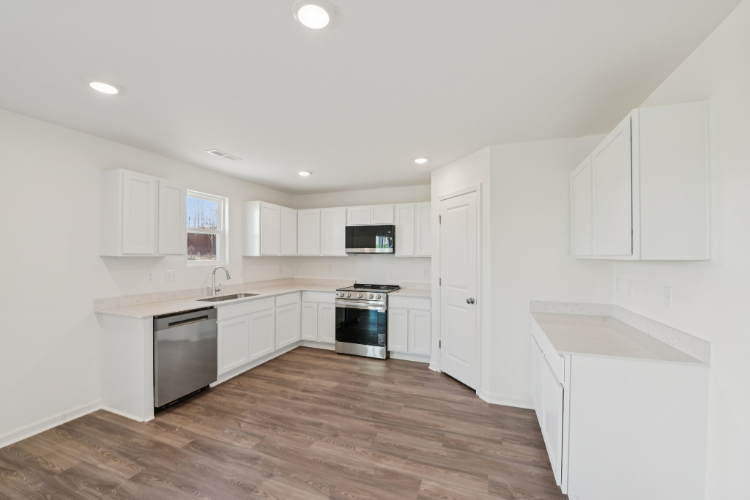 A kitchen with white cabinets.