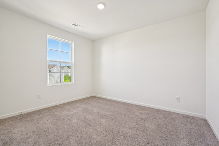 A room with a window and a carpet.