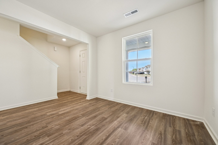 A room with a wood floor and a window.