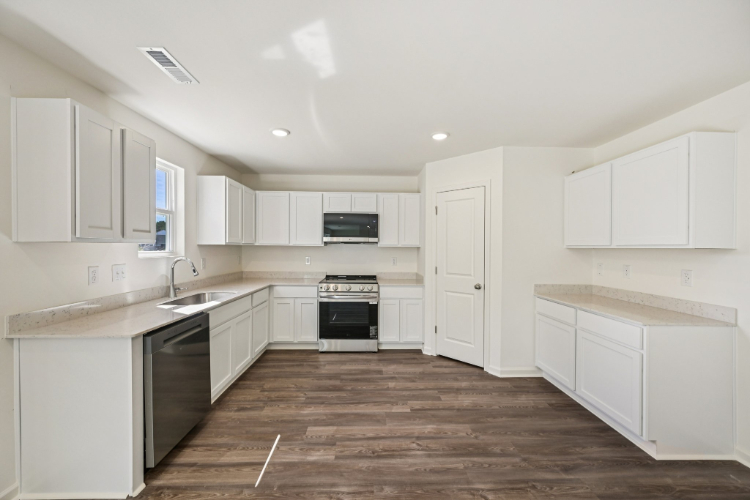 A kitchen with white cabinets.