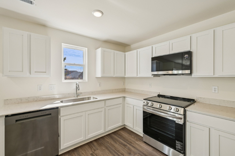 A kitchen with white cabinets.