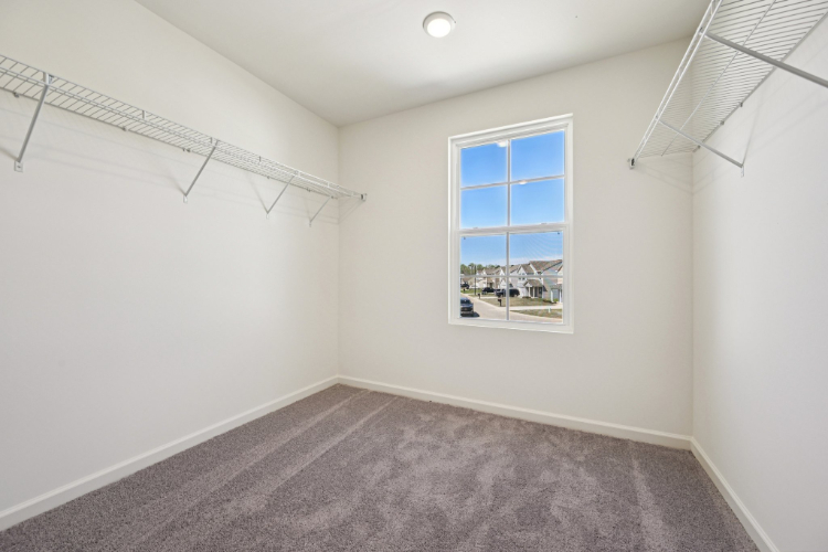 A room with a window and a carpet.
