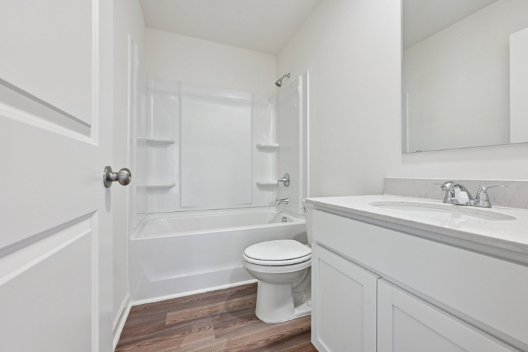 A bathroom with a tub sink and toilet.