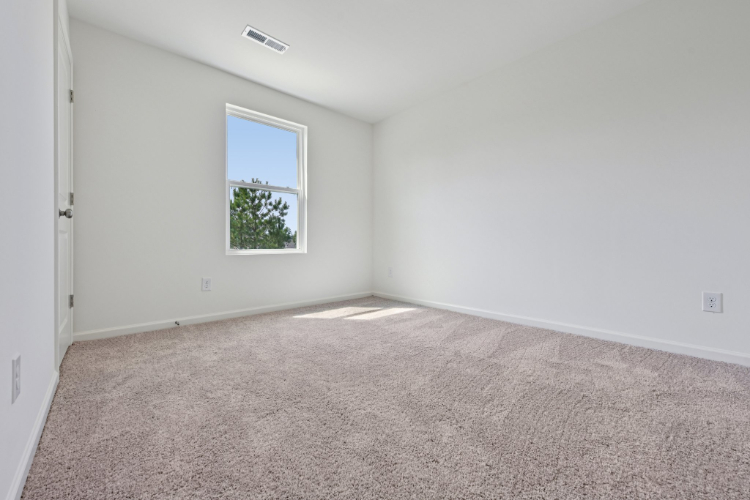 A room with a carpet and a window.