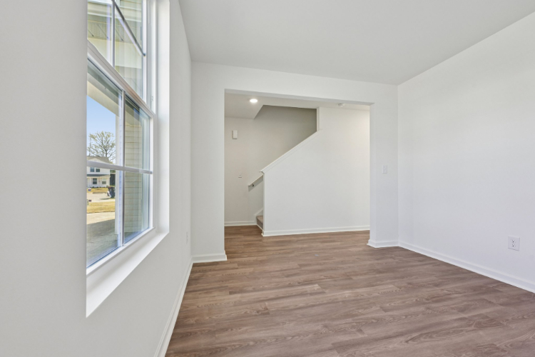 A room with a wood floor and windows.
