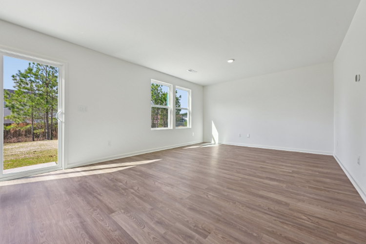 A room with a wood floor and windows.