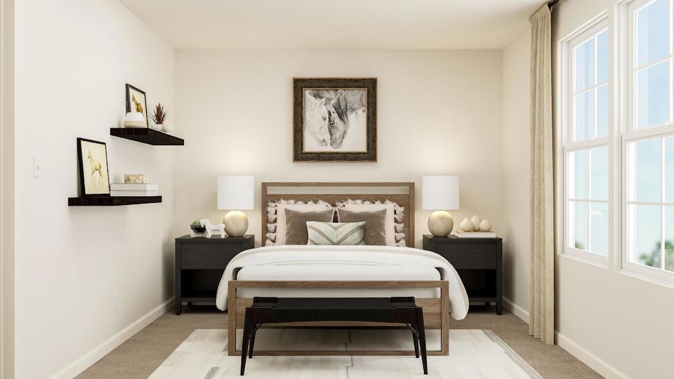 A bedroom with a bed and a shelf with pictures on it.