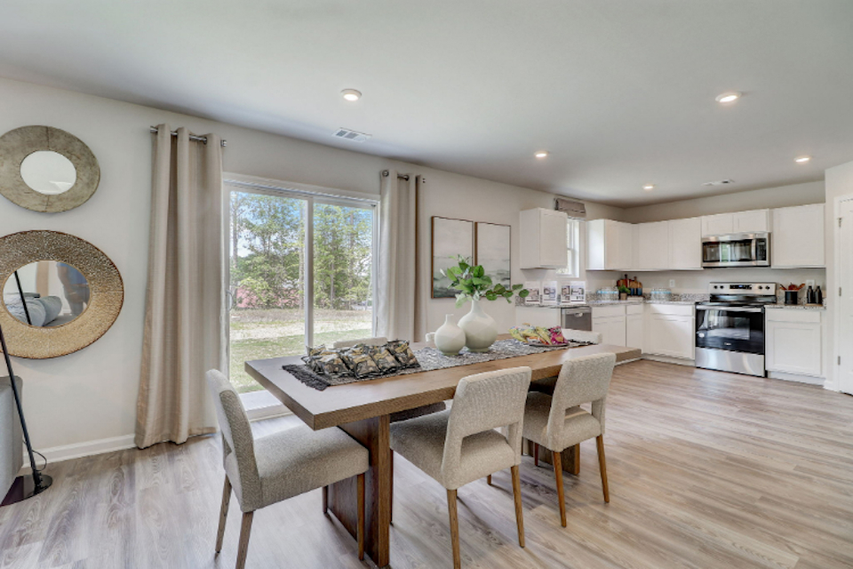 A kitchen with a dining table and chairs.
