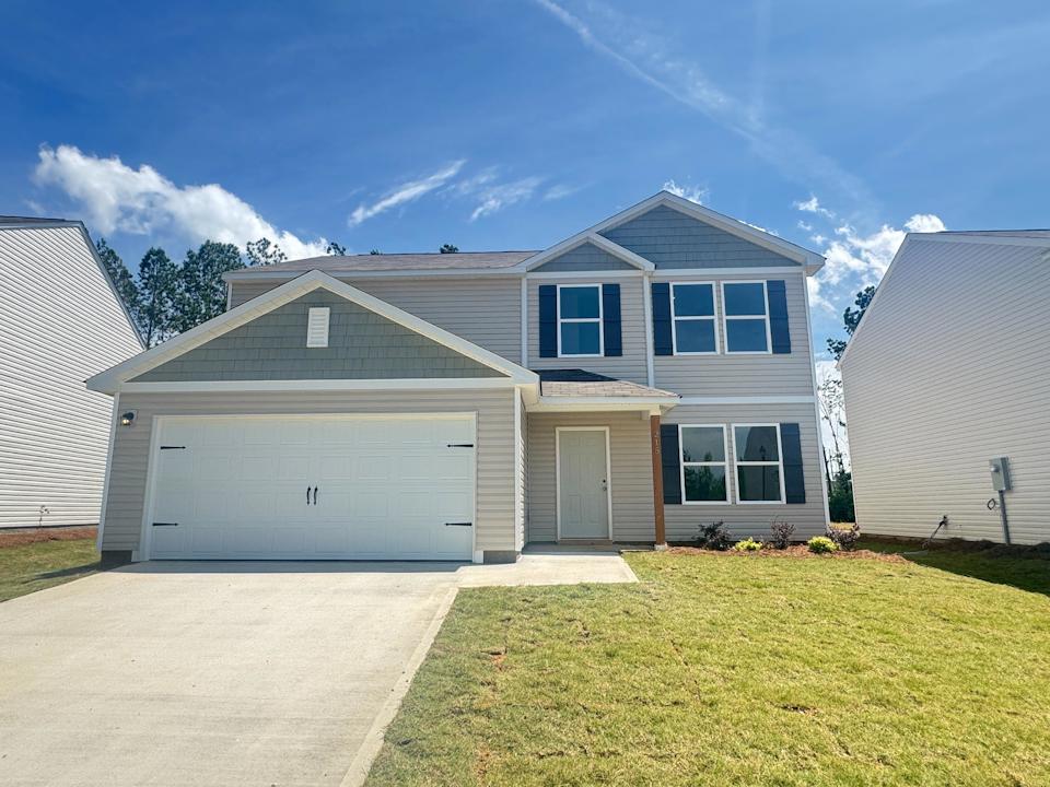 A house with garages and grass.